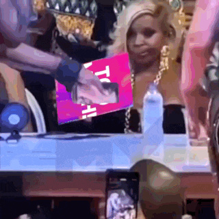 a woman sitting at a table with a sign that says " to all " on it