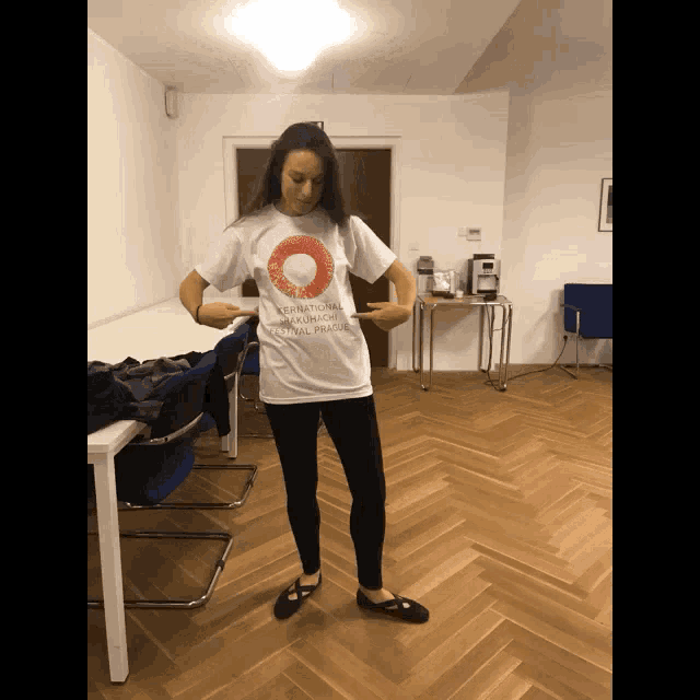 a woman wearing a white shirt that says international taekwondo festival prague on it