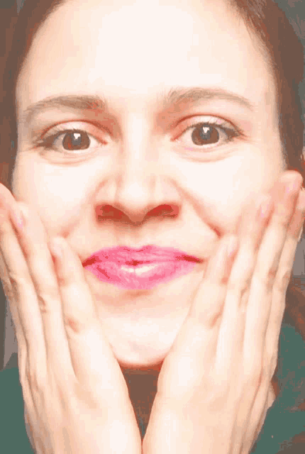a close up of a woman making a funny face with her hands on her face