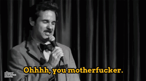 a man in a suit and bow tie is holding a microphone and saying ohhhh you motherfucker