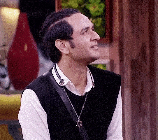 a man wearing a black vest and a necklace with a star of david on it