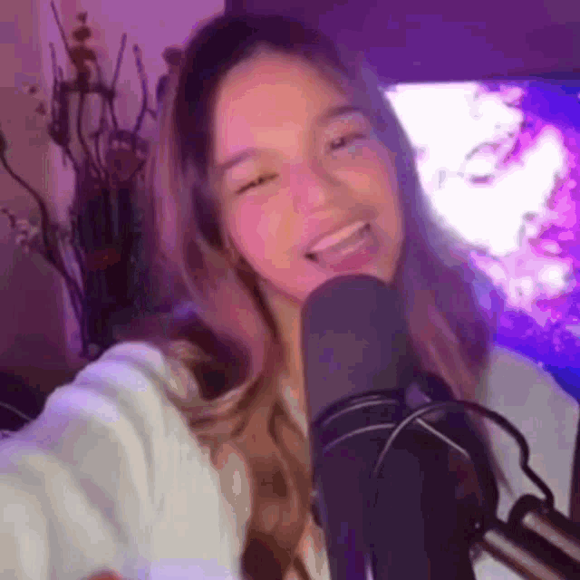 a young woman is taking a selfie in front of a microphone .