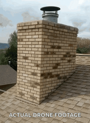a brick chimney on top of a roof with the caption actual drone footage