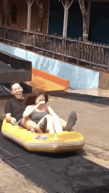 a man and a woman are sledding down a hill