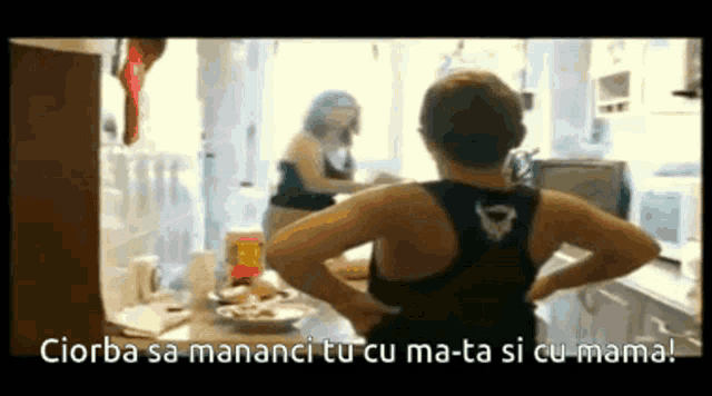 a woman in a black tank top is standing in a kitchen with the words ciorba sa mananci tu cu ma-ta si cu mama