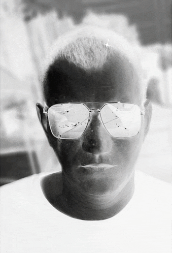 a black and white photo of a man 's face with sunglasses on