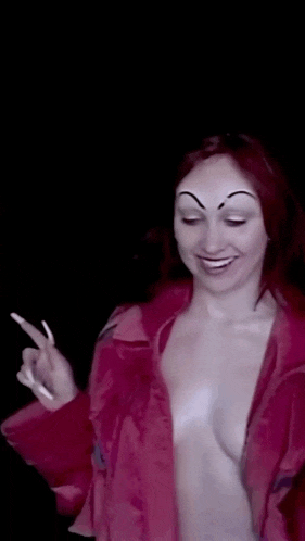 a woman without a shirt has a drawing of a face on her eyebrows