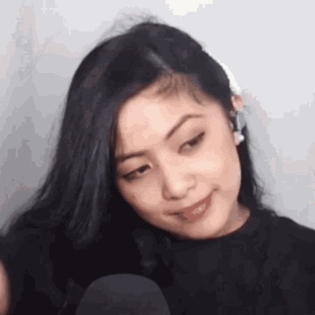 a close up of a woman wearing headphones and a black shirt making a funny face .