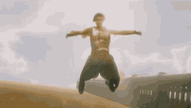 a man is jumping in the air with his arms wide open