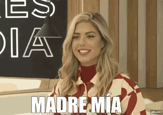 a woman is smiling in front of a blackboard that says madre mia
