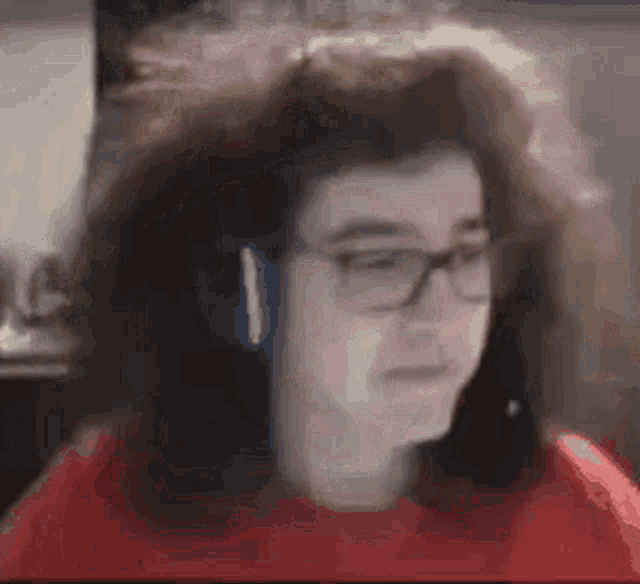 a close up of a person wearing headphones and a red sweater .