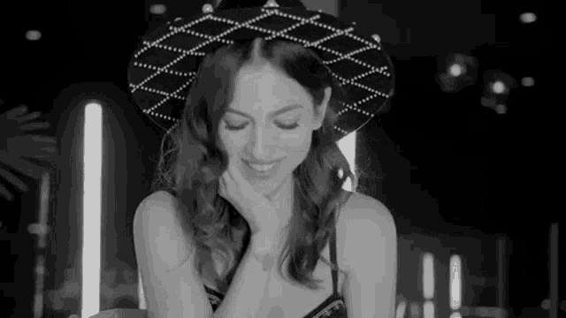 a black and white photo of a woman wearing a hat