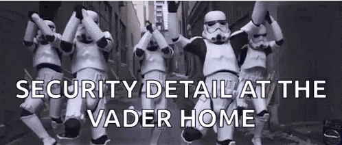 a group of stormtroopers are dancing in a row in a street .
