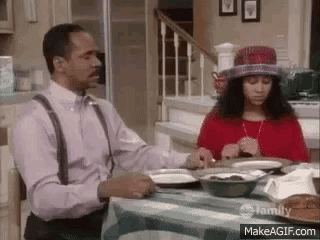 a man and a woman are sitting at a table with plates of food .