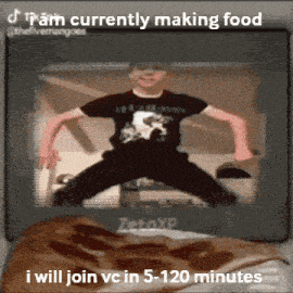a boy in a black shirt is jumping in front of a screen that says i am currently making food