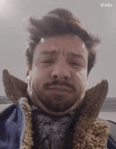 a man with a beard is wearing a scarf around his neck .