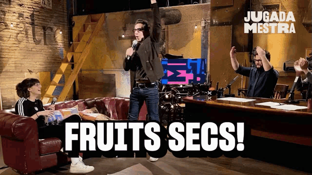 a man stands in front of a microphone with fruits secs written on the bottom