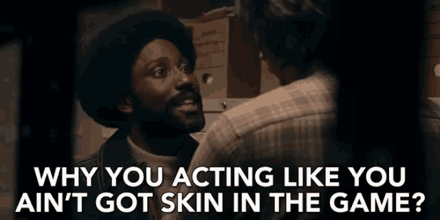 a man talking to another man with the words " why you acting like you ain t got skin in the game "