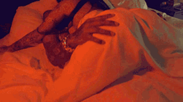 a person laying on a bed with a hand on their stomach