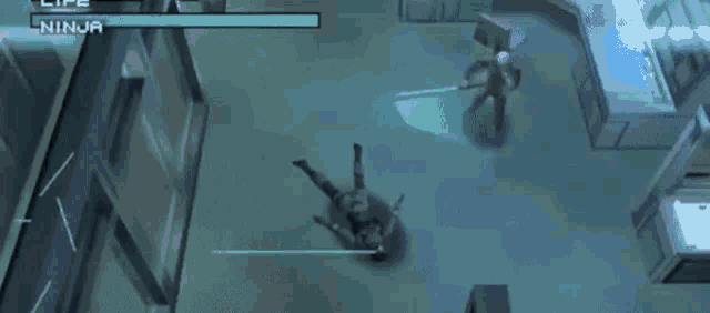 a man is laying on the floor in a video game while another man is fighting him .