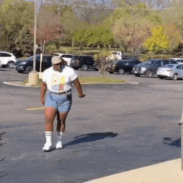 a man wearing shorts and socks is walking in a parking lot .