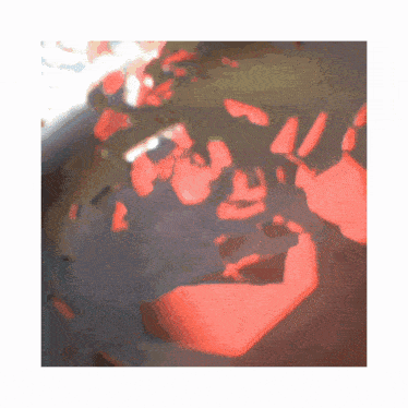 a blurry picture of a person 's face with a red shadow on it