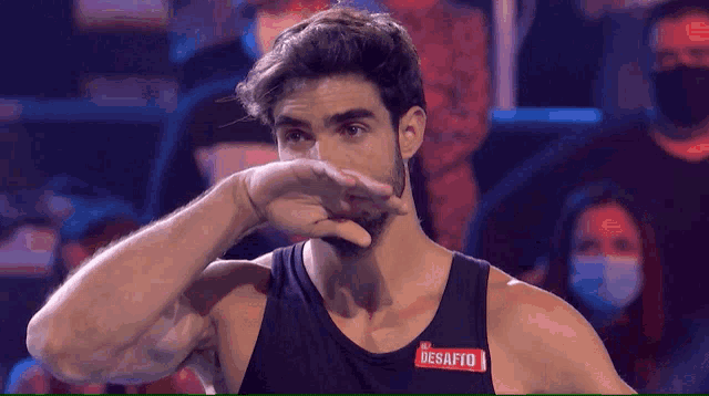 a man wearing a black tank top with a red label that says desafio