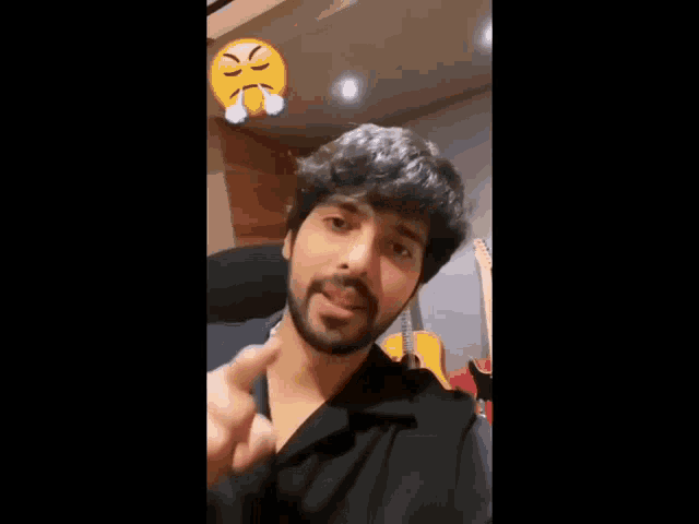 a man with a beard is sitting in front of a guitar and making a funny face