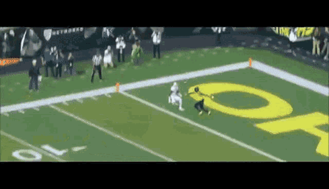 a football game is being played on a field with a large yellow letter o on it .