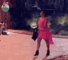 a woman in a pink dress is walking down the street