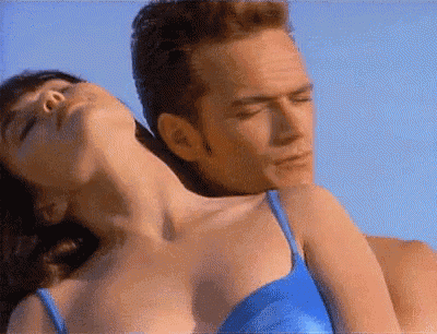 a woman in a blue bikini is laying on a man 's back