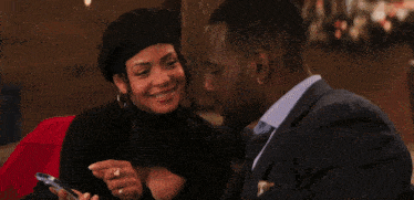 a man and a woman are looking at each other with a santa hat in the background