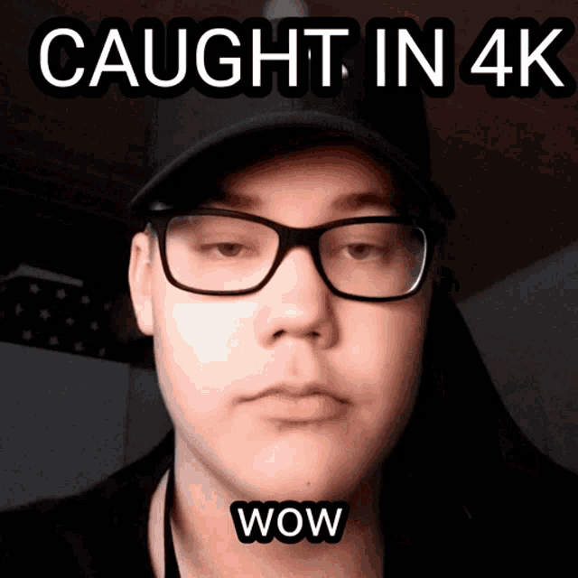 a man wearing glasses and a black hat with the words caught in 4k wow