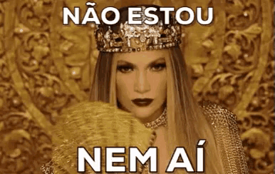 a woman wearing a crown and holding a fan with a foreign language caption .