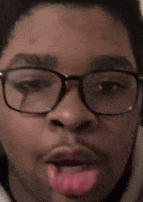 a close up of a person wearing glasses with their tongue sticking out .