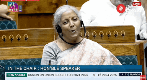a woman wearing headphones is sitting in a chair with the words in the chair hon ble speaker on the bottom