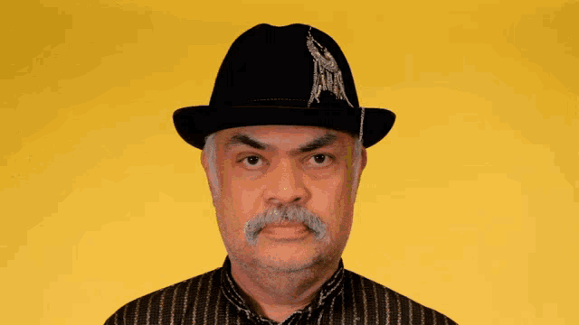 a man wearing a black hat with a feather on it