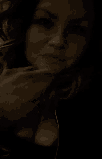 a close up of a woman blowing a kiss with her mouth open