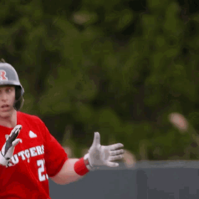 a baseball player wearing a red rutgers jersey with the number 23 on it