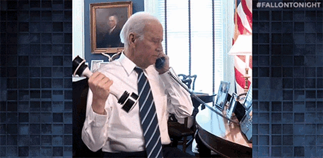 a man is talking on a phone while holding a dumbbell