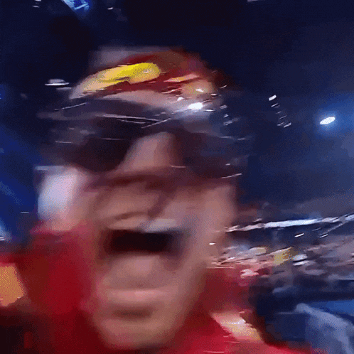 a blurry photo of a man wearing sunglasses and a red shirt