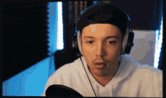 a man wearing headphones and a baseball cap is looking at the camera