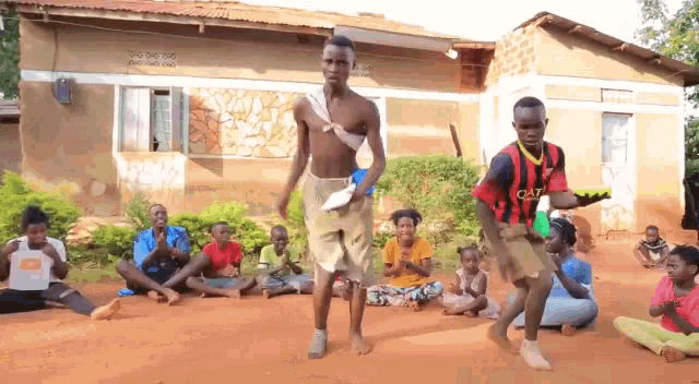 a man in a cat shirt is dancing in front of a group of kids