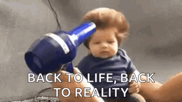 a baby is getting his hair blow dried by a person with a hair dryer .
