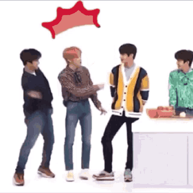a group of young men are standing next to each other in a kitchen and dancing .