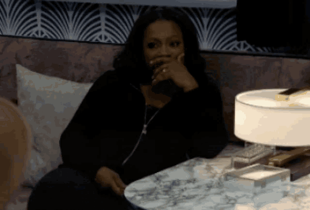 a woman is sitting on a couch with her hand on her face