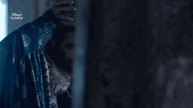 a disney + hotstar ad with a man wearing a fancy hat