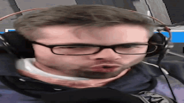 a man wearing glasses and headphones is making a face