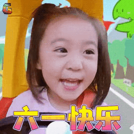 a little girl is smiling while sitting in a toy car with chinese writing on it