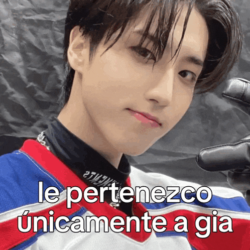 a young man wearing a red white and blue jersey with the words le perteneco unicamente a gia
